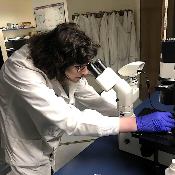 Eli Perr looking into a microscope